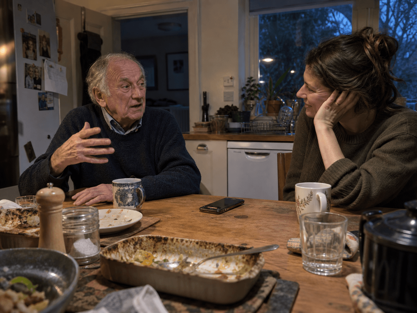 A multigenerational family sharing stories in a kitchen after dinner